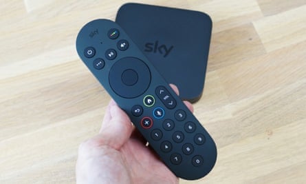 Sky Stream box and remote control on a wooden table.