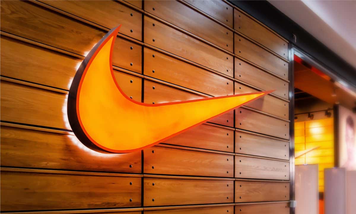 An orange Nike logo lights up against a wooden background.