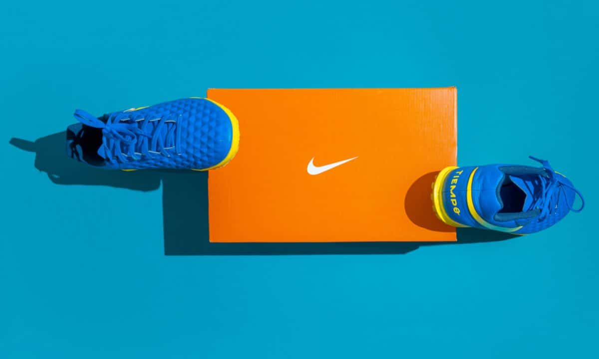 A pair of Nike sneakers and the Nike logo on a blue background.