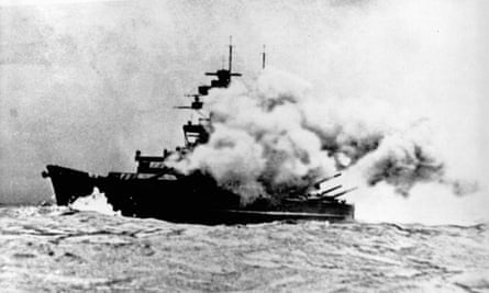 Warship engulfed in smoke from the firing of the main guns 