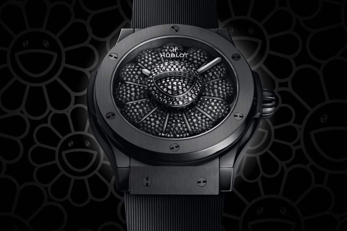 A black hublot watch is shown against a black background.