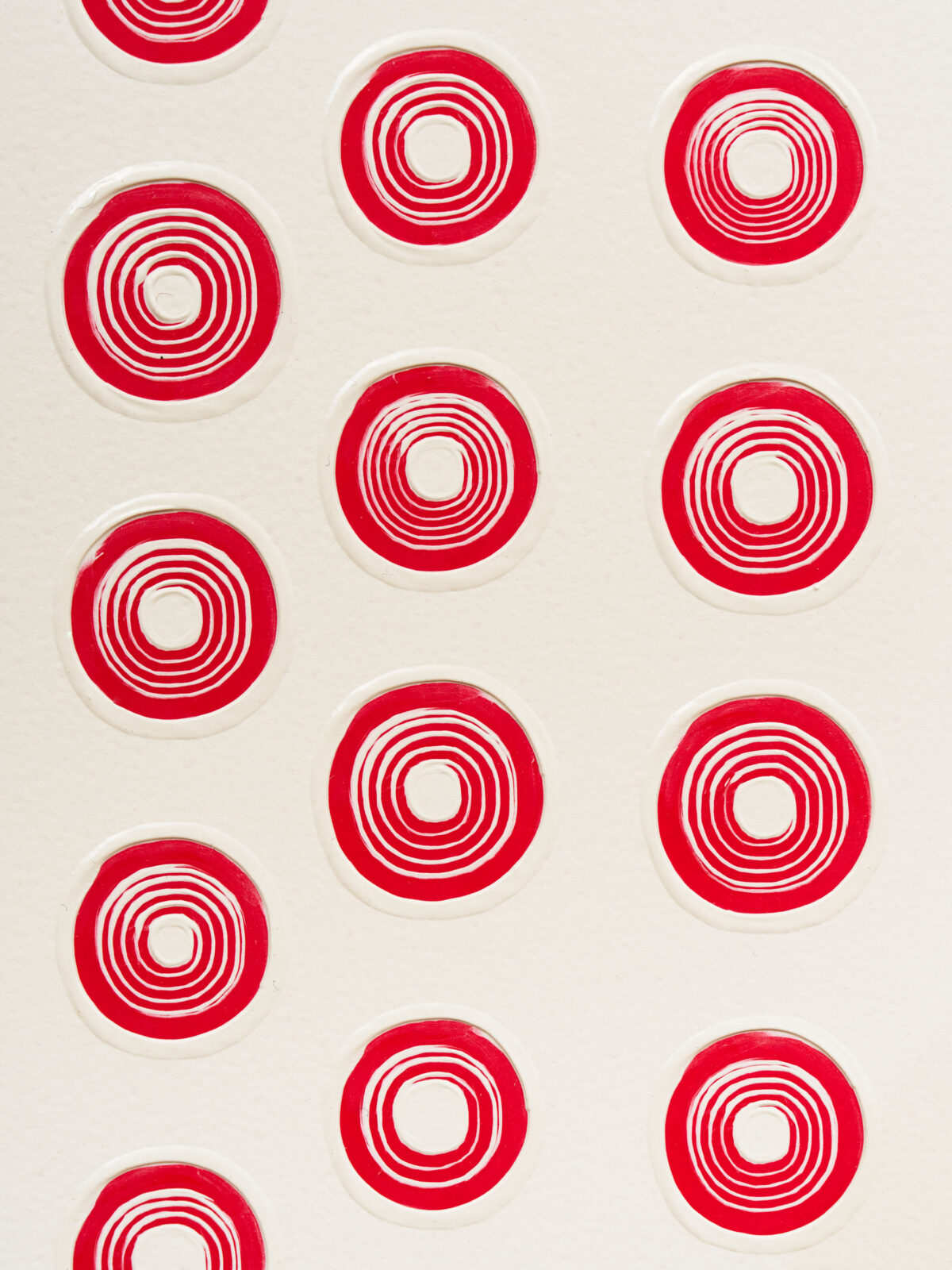 A grouping of rotating red circles on a grayish white background.