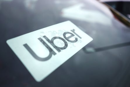 An Uber sticker on the windshield of a car.