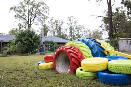 A dog play tunnel built from brightly painted tractor tires, in a suburban backyard.