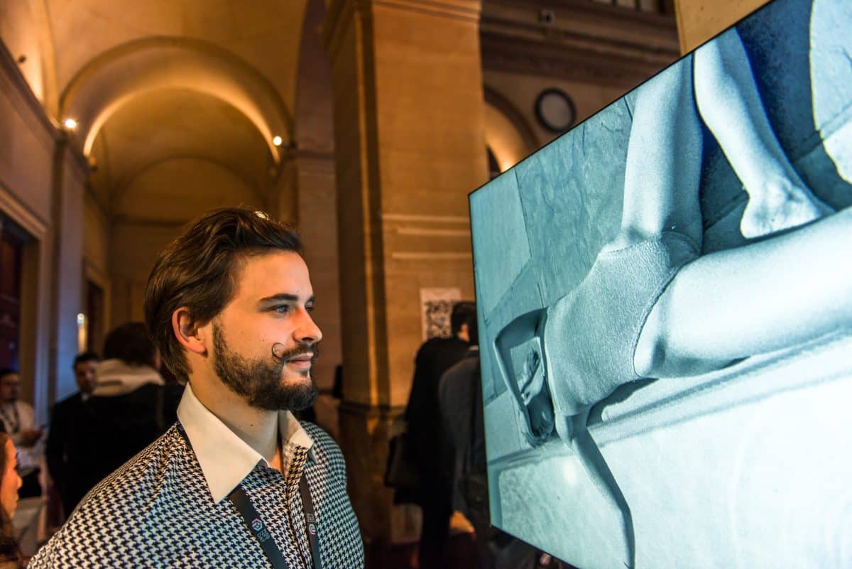 image of a man looking at a photograph of a woman during Blockchain Week in Paris