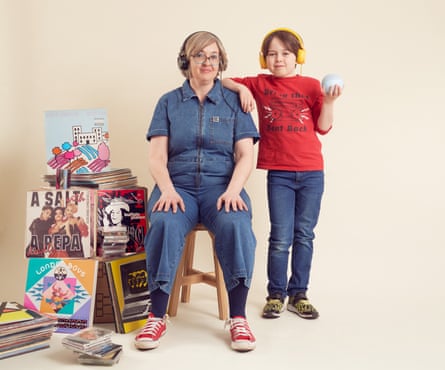 Jude Rogers fotografiada con su hijo de 9 años en su casa, junto a una pila de álbumes.
