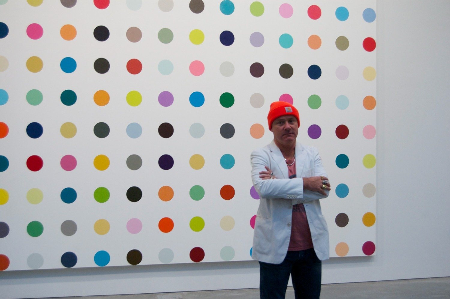 Damien Hirst NFT photo standing in front of art