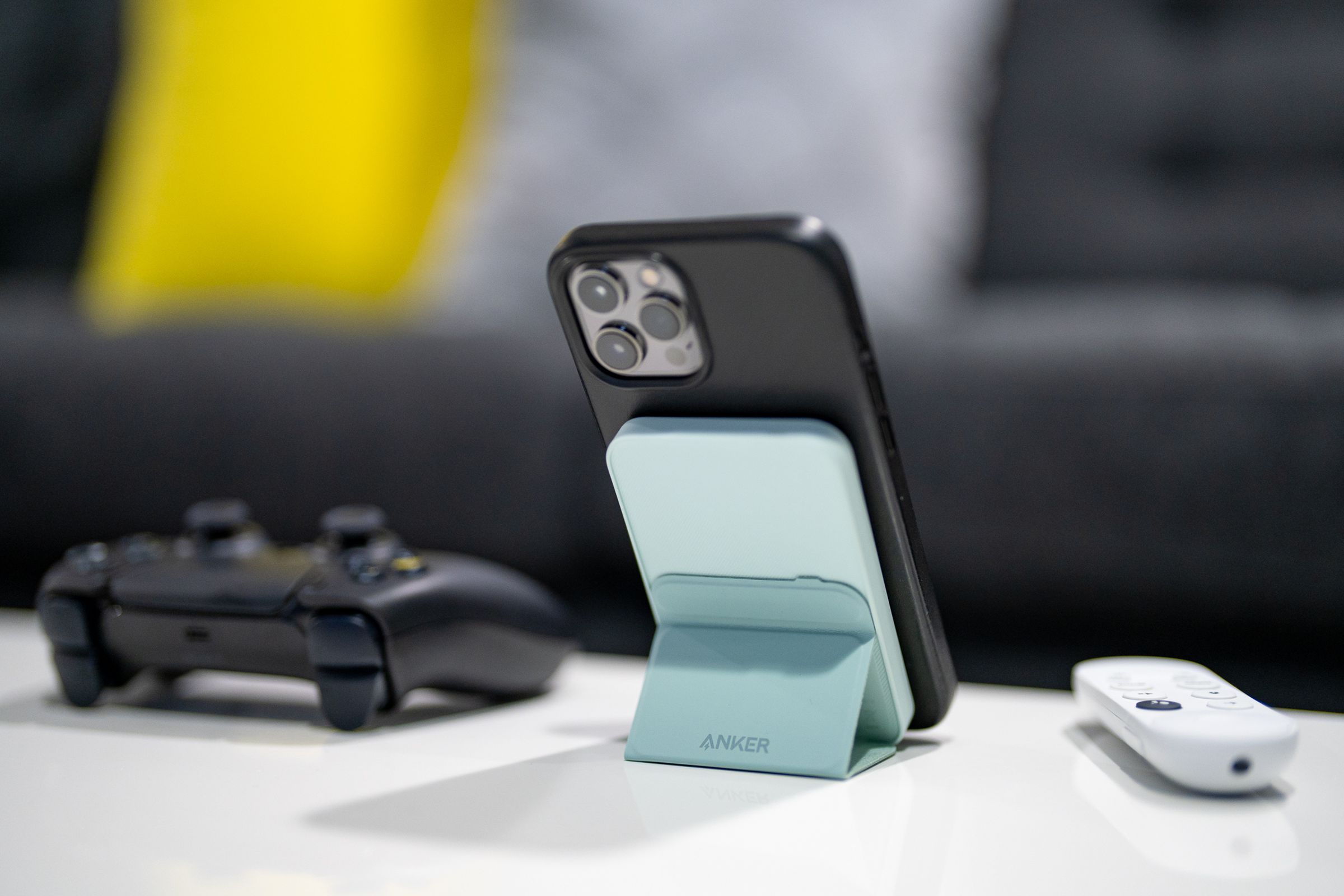 Anker's Magnetic Battery 621 (MagGo) holds an iPhone with its stand on a desk.