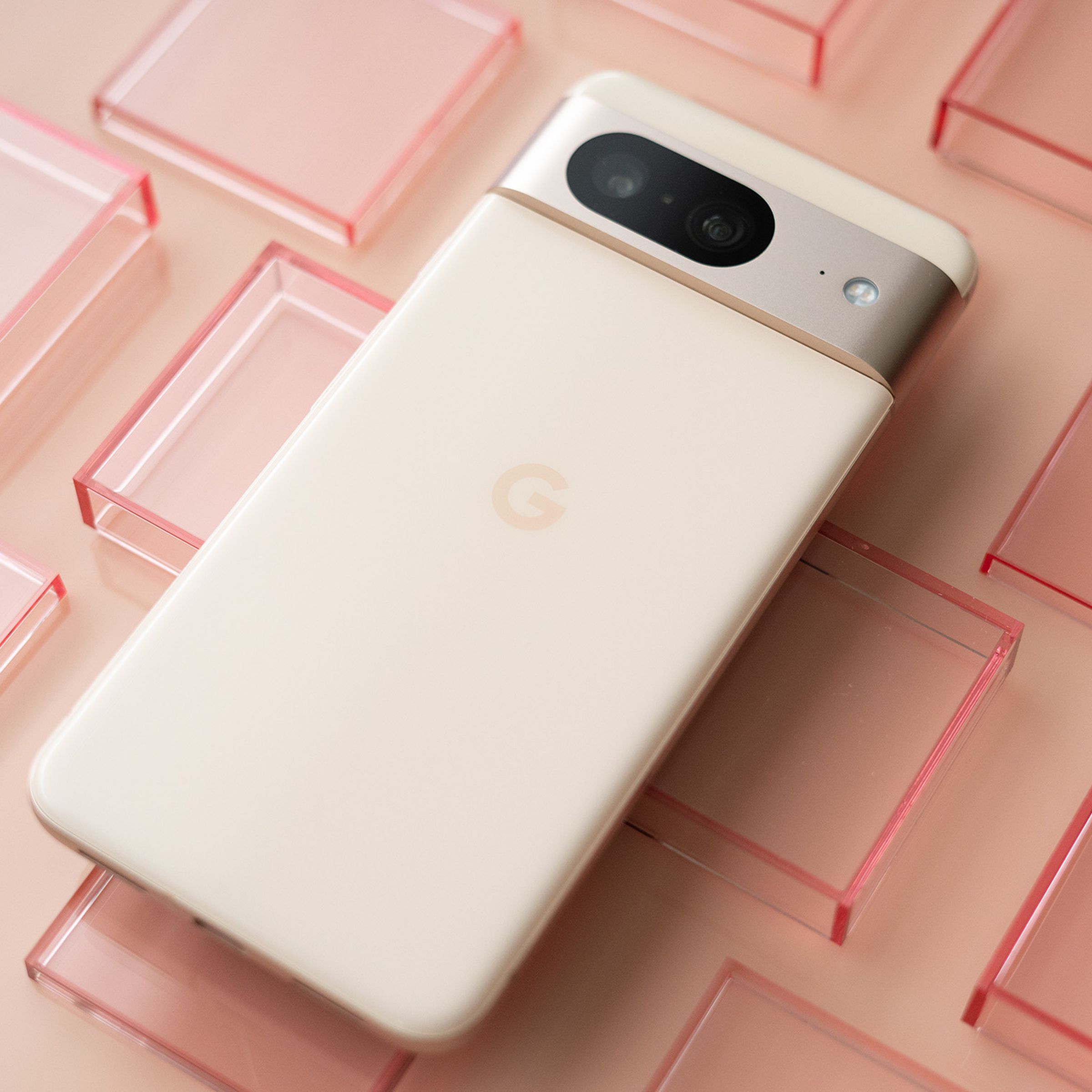 Google Pixel 8 in pink on a pink background with transparent red squares.