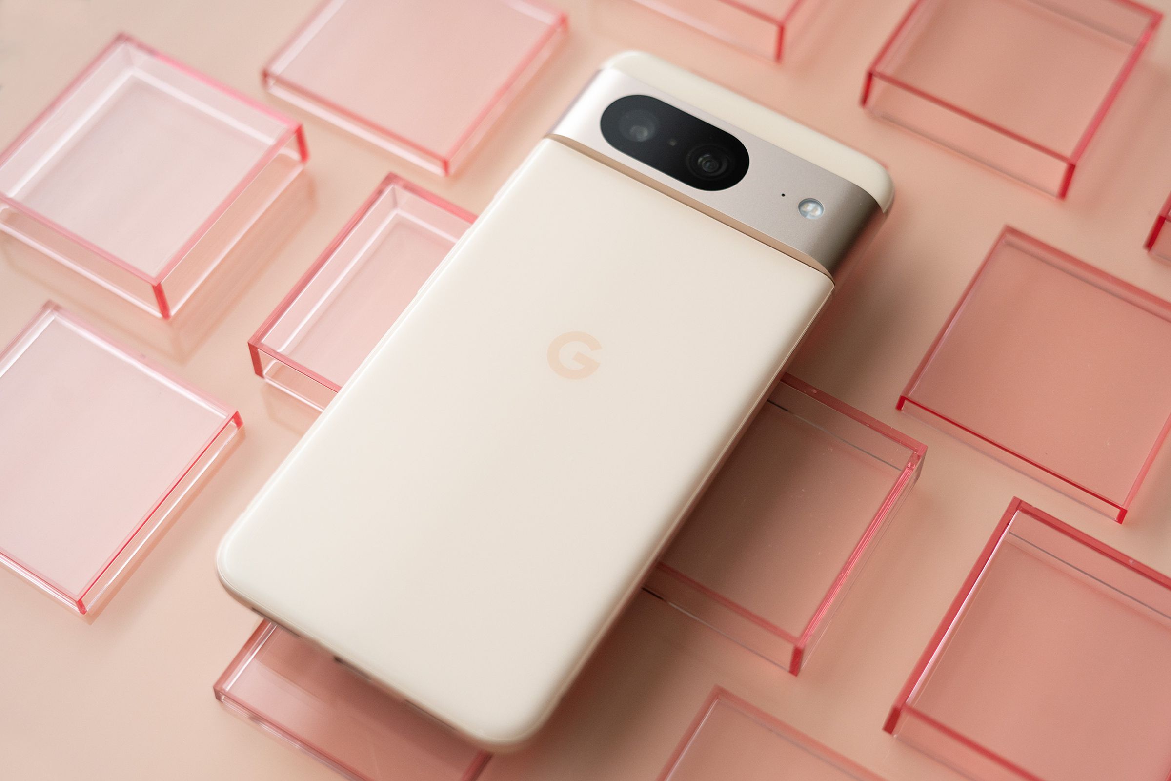 Google Pixel 8 in pink on a pink background with transparent red squares.