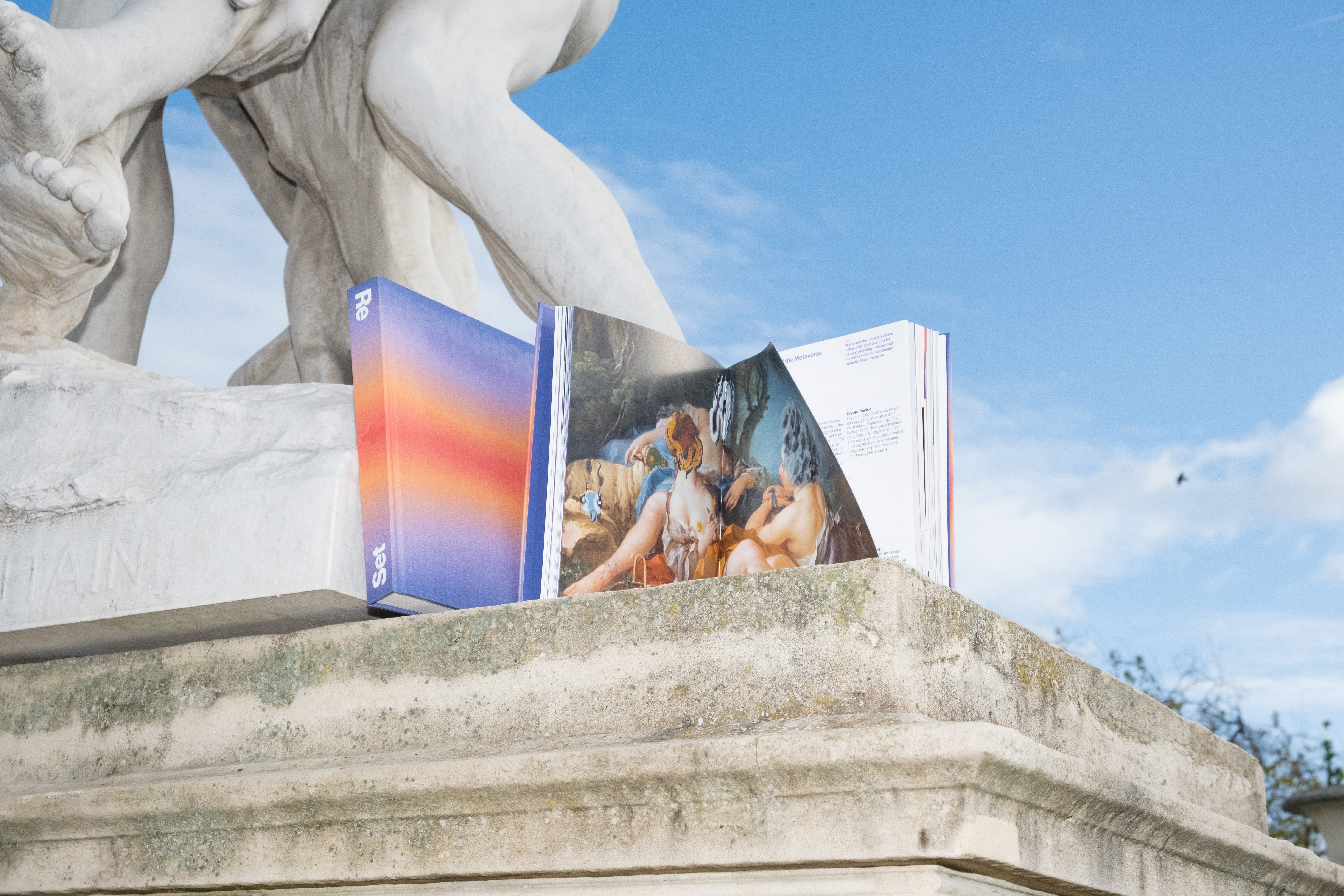 An incredible photograph of the book New Society in a stylized form under a statue