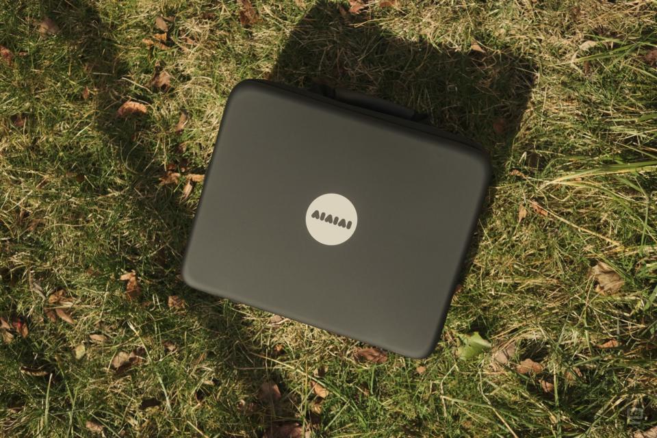 AIAIAI Unit 4 Wireless+ in their carrying case laying on the grass.