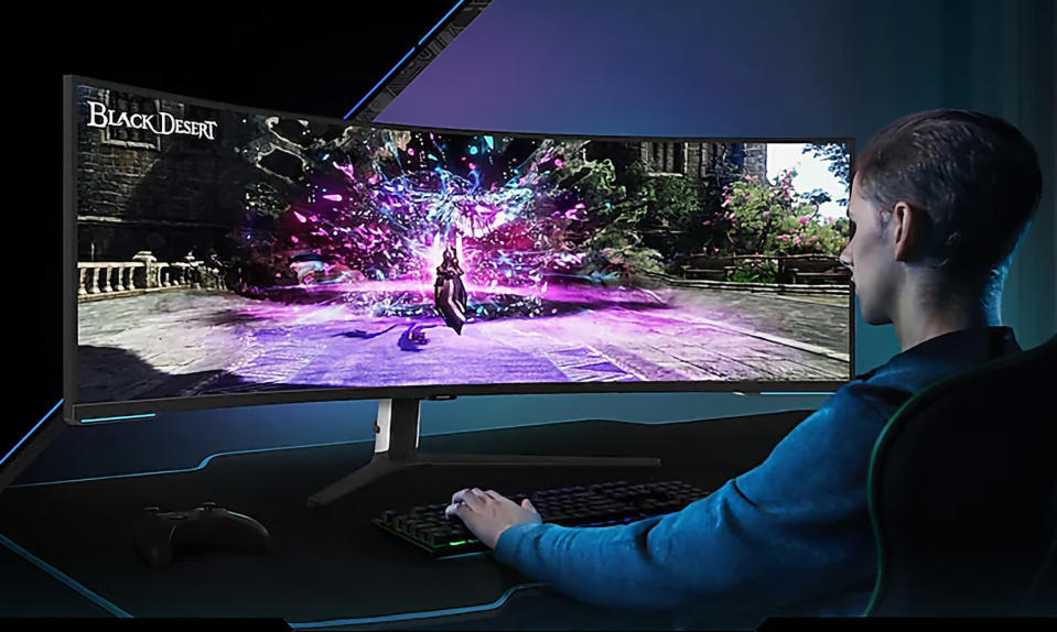 Product lifestyle image of young adult playing game on ultra wide Samsung monitor.