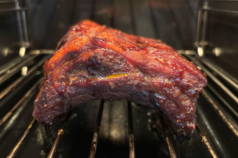 Baby back ribs sitting on a rack inside of the GE Profile Smart Indoor Smoker.