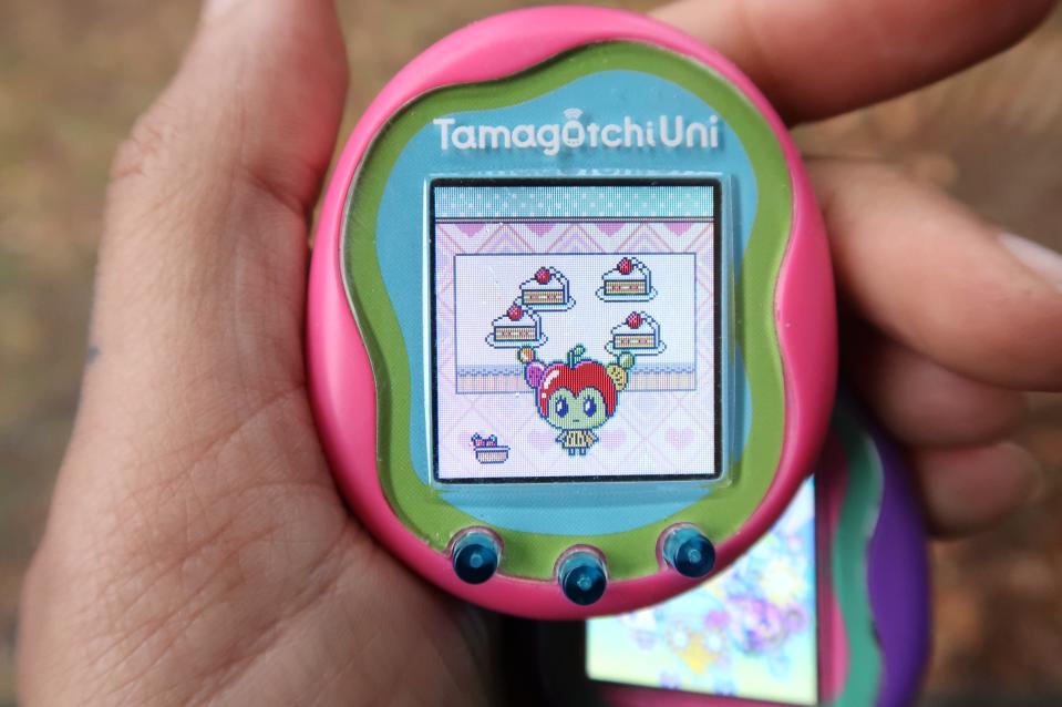 Pink Tamagotchi Uni photographed in a hand showing the new Tanghulutchi character
