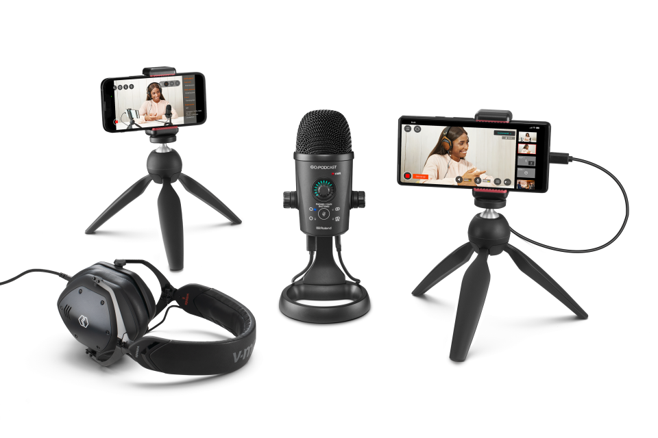 Product marketing photography for the Rode Go:Podcast mobile studio.  In the center is a desktop microphone, flanked by two smartphones on mini tripods (which display the podcast video on their screens) and a pair of headphones.