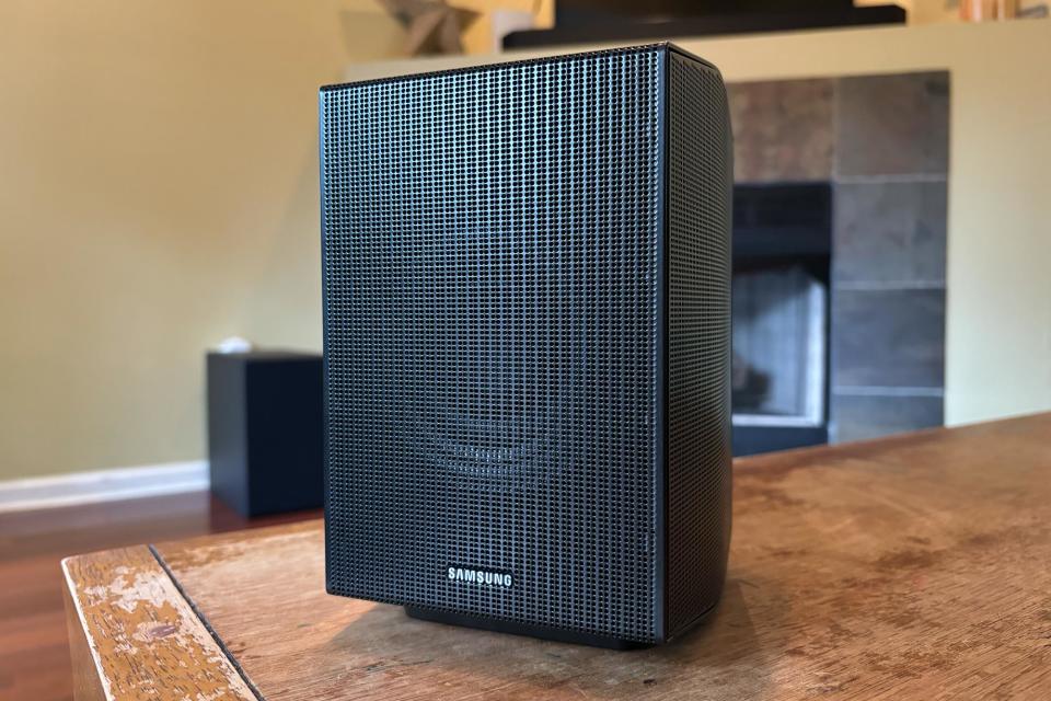 One of the Q990D's rear speakers on a wooden table. 