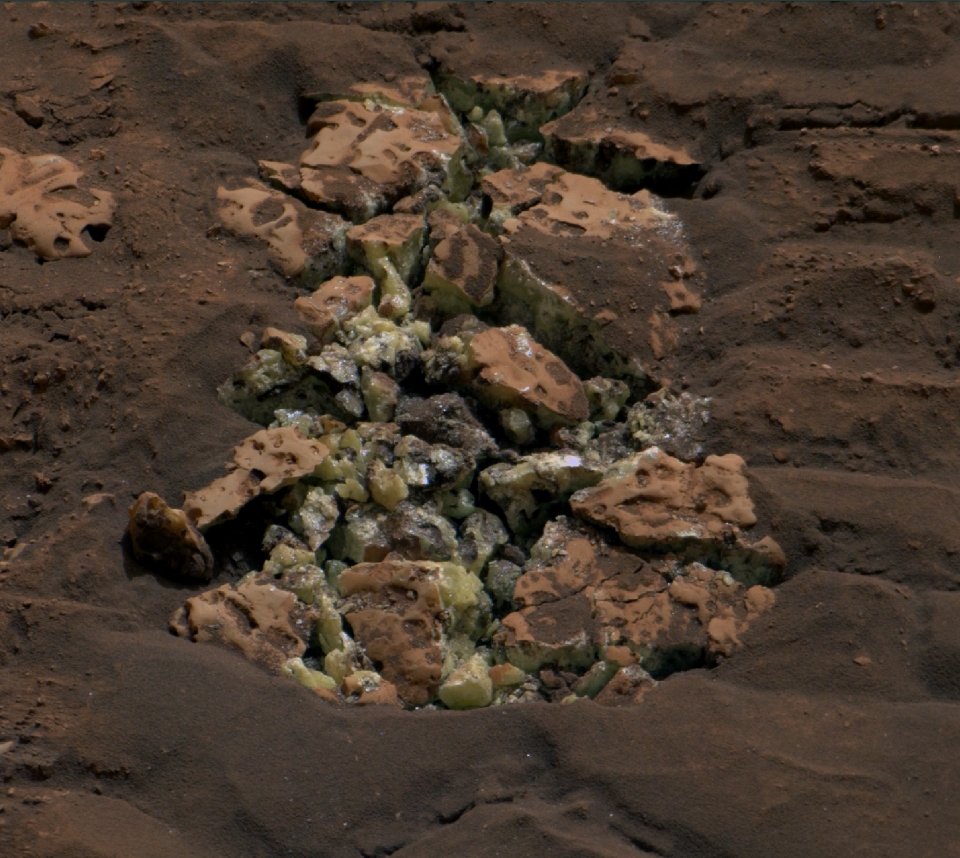 A rock crushed and cracked by the Curiosity rover reveals yellow sulfur crystals