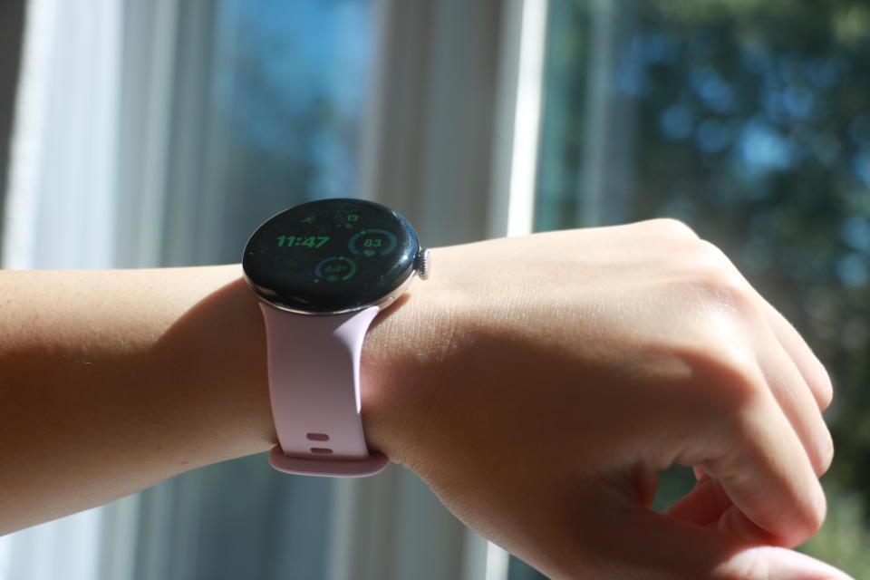 A downward-up angle of the Pixel Watch 3 on a person's wrist in the sun. Its sides are shiny.