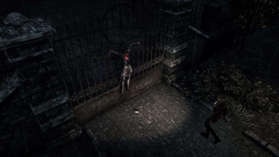 A woman's body is tied to an iron gate in the middle of a cobblestone road. Mica is seen walking towards her, shining her flashlight on the corpse.