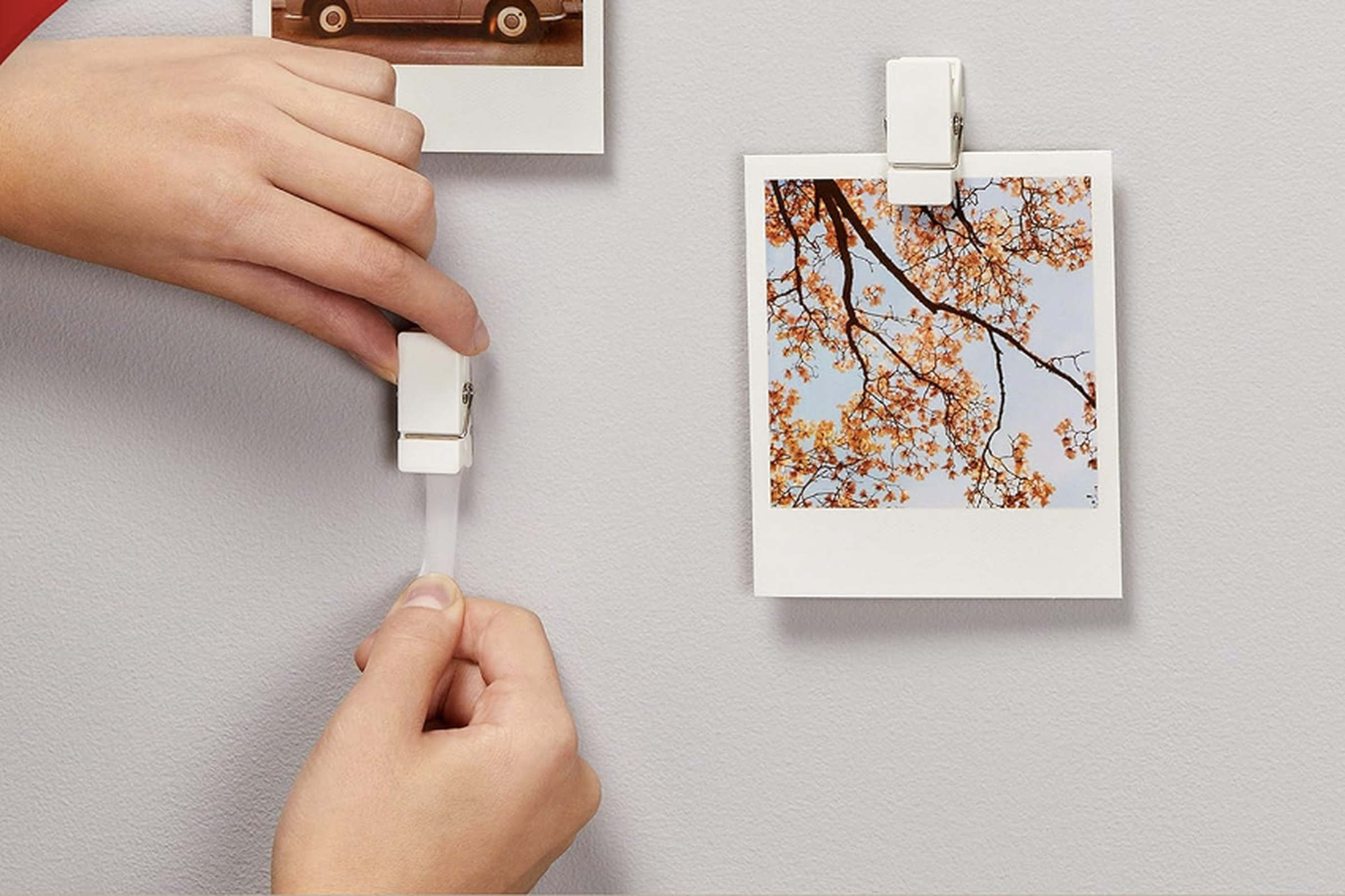 Attach the clip with tape to the wall with your hand and other clips hold the photos.