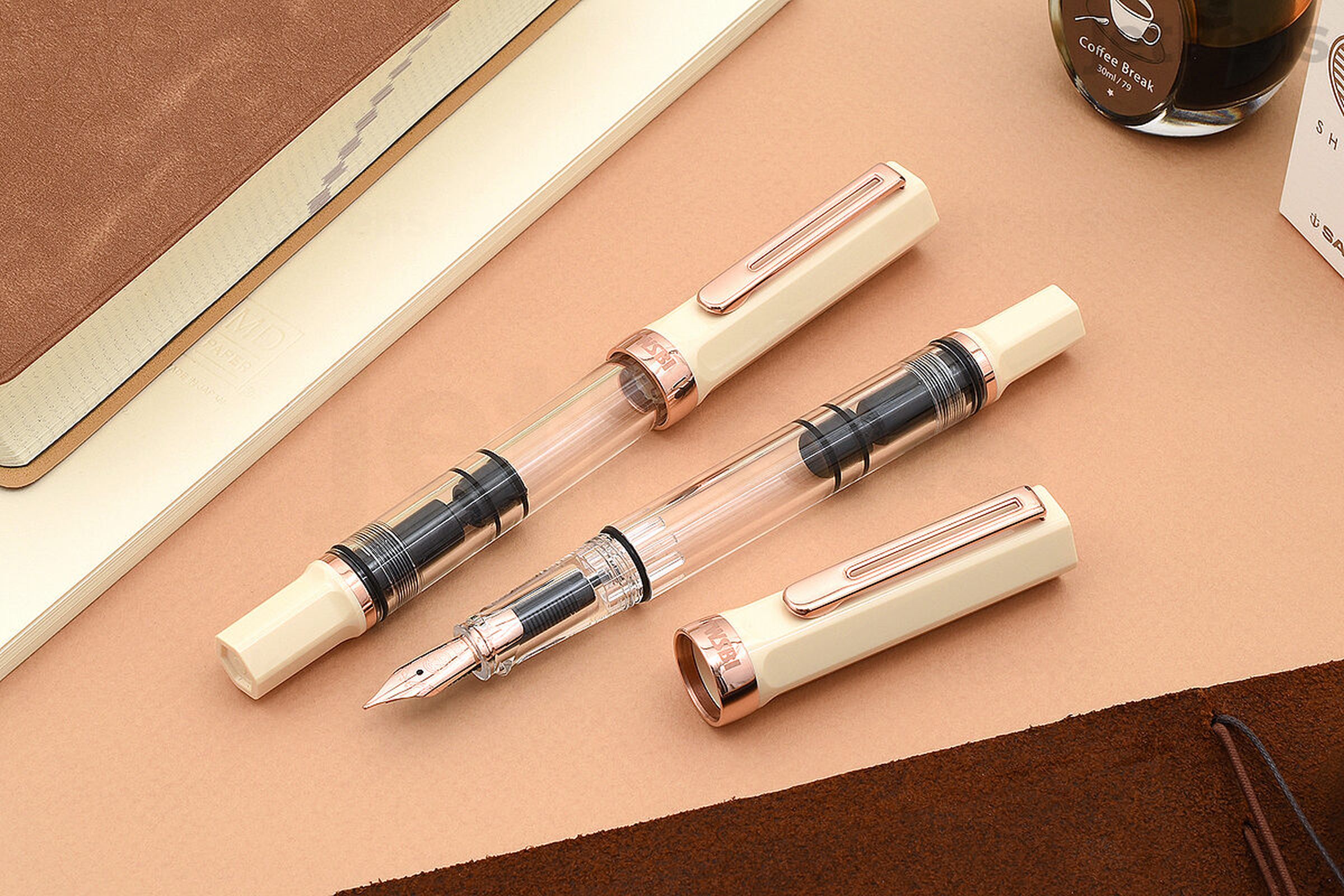 Three-piece rose gold fountain pen on a table top.