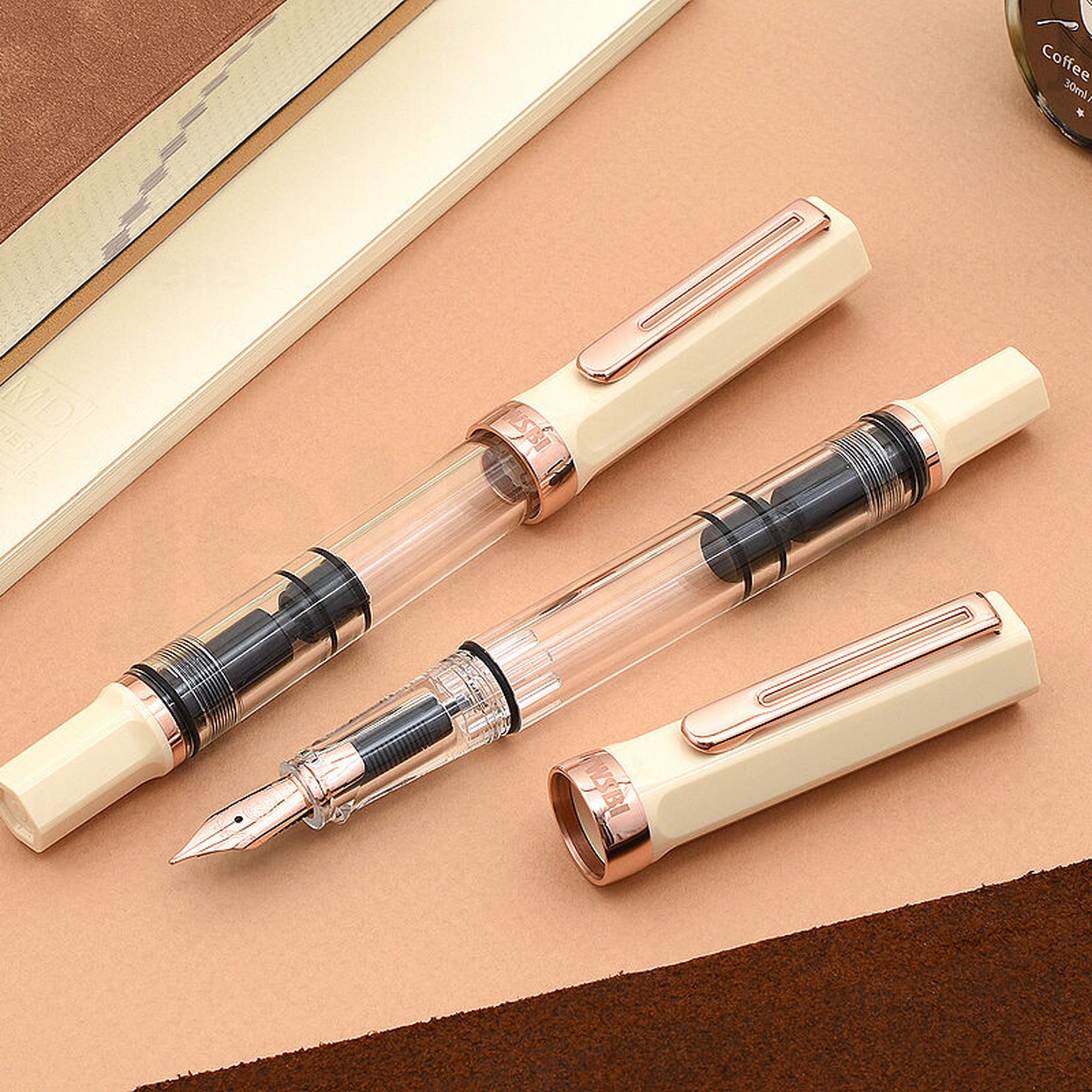 Three-piece rose gold fountain pen on a table top.