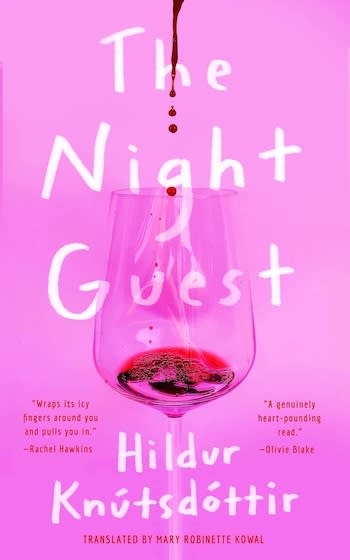 The cover of The Night Guest. It has a bubblegum pink background and in the foreground you can see a wine glass with a small amount of red liquid dripping into it.