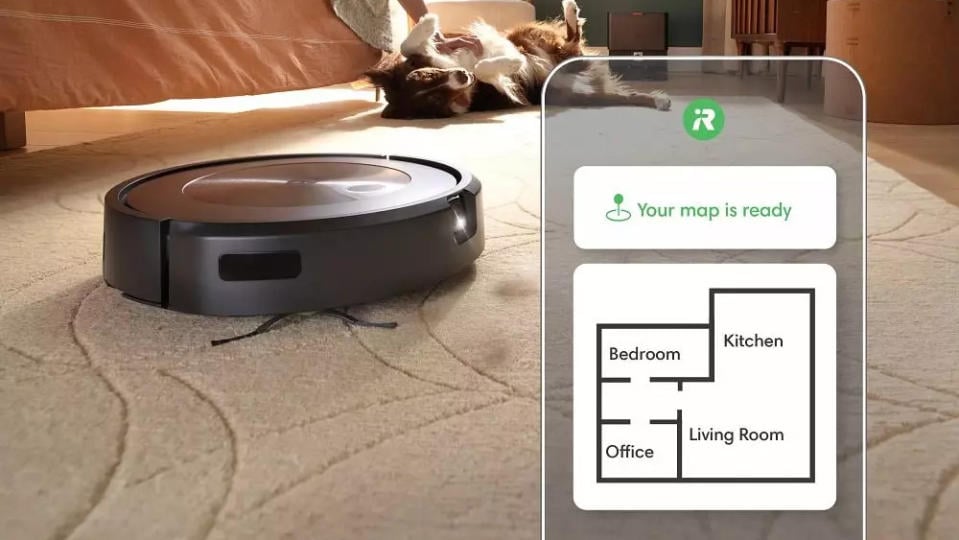 Product image of the iRobot Roomba j9+. The robot moves on a carpet with a dog in the background. Overlay smartphone app showing off its mapping capabilities.