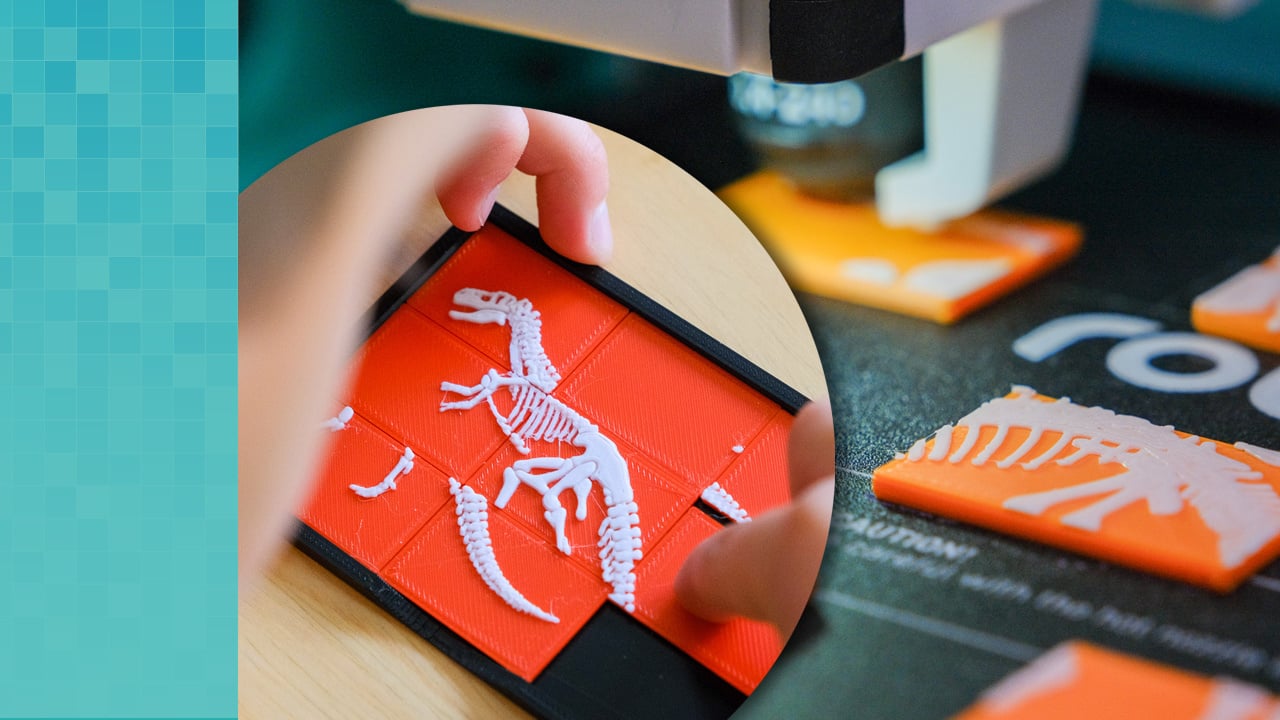     Inset image of a hand playing with a dinosaur, a three by three puzzle. The image is overlaid on a close-up of the Robo E4 3D printer's build plate with 3D printed dinosaur puzzle pieces.