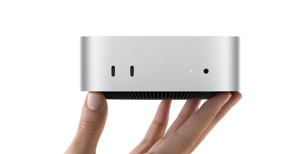 Close-up of a person's hand holding the new (small) Mac mini