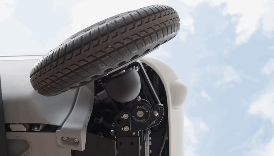 Bottom view of an Avride delivery robot. Its wheel is attached to a mechanical arm that allows it to slide along a circular path.