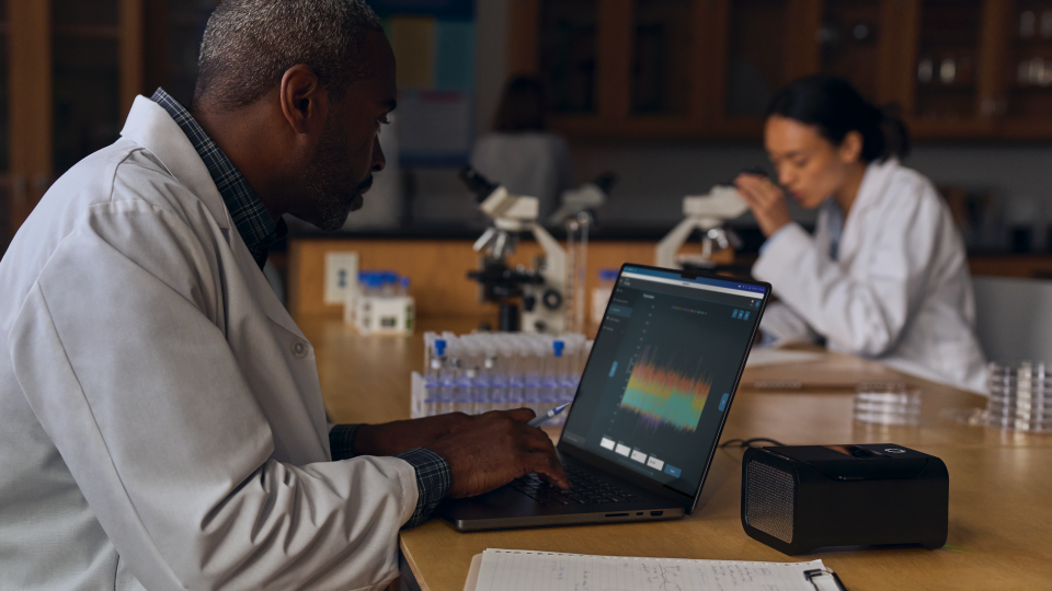 A person sitting in a lab using the new MacBook Pro with M4 chip.