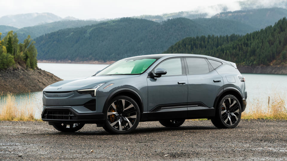 The Polestar 3 sitting in front of a lake surrounded by trees and hills.