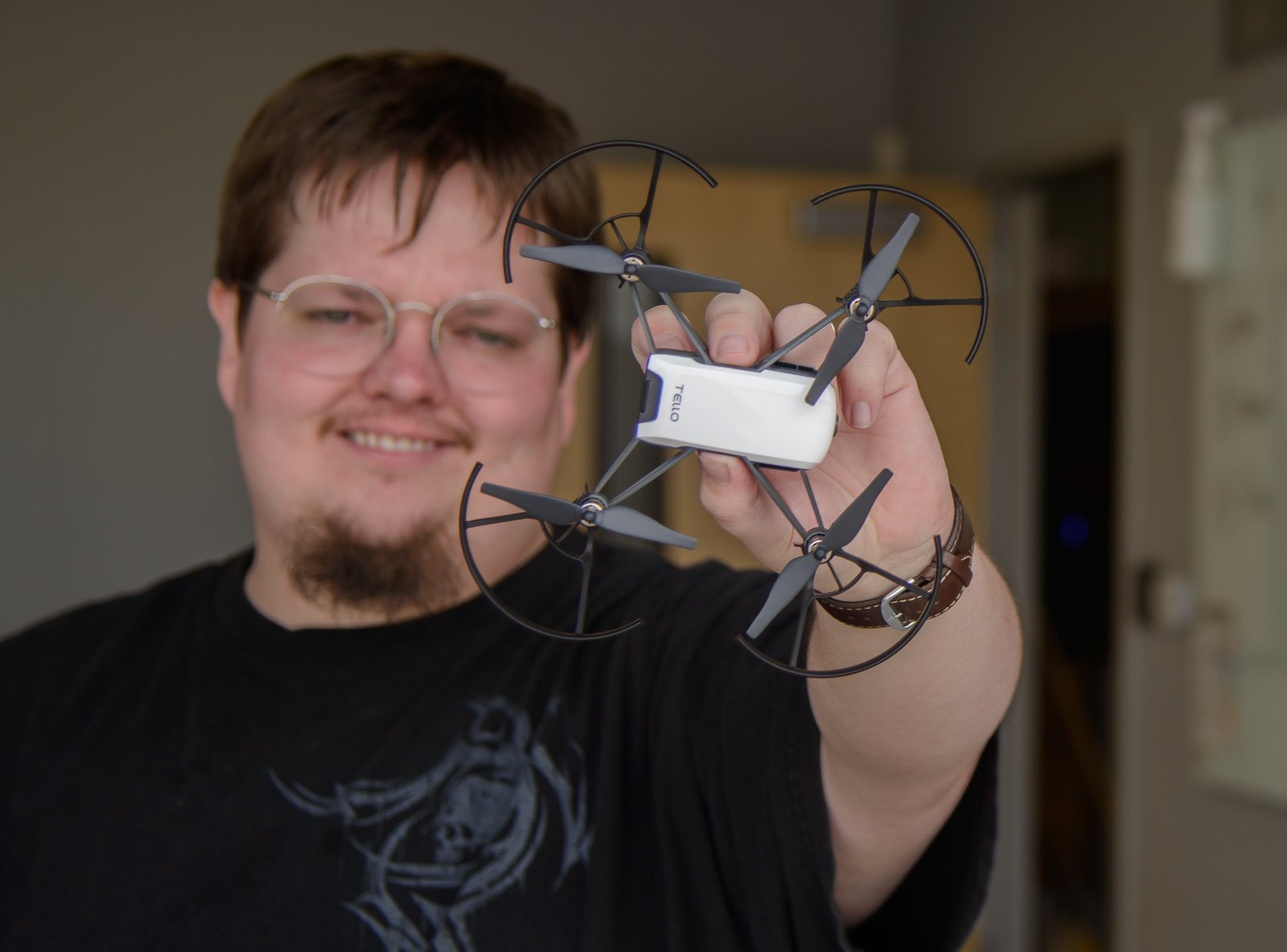 A college student brings a small drone closer to the camera