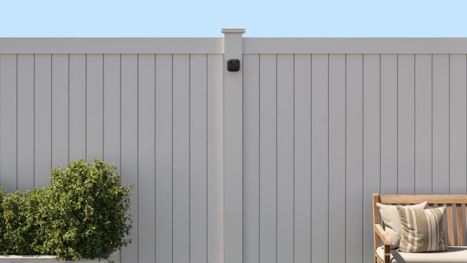 The Blink Outdoor 4 security camera mounted on an outside fence.