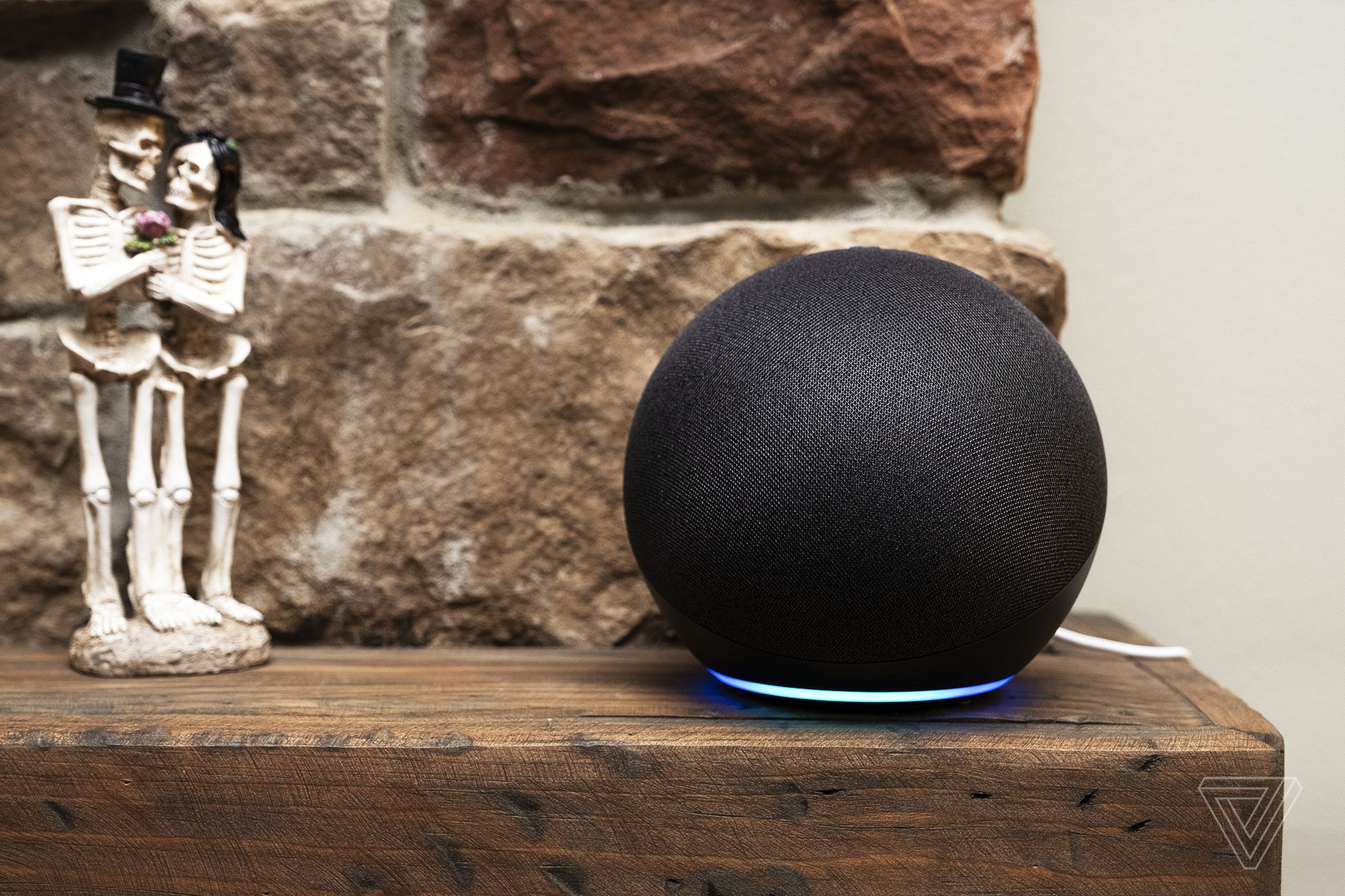 An Echo smart speaker on a mantlepiece with a skeleton couple.